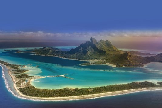 High angle view of beautiful Bora Bora island, a gem in the French Polynesian islands, as seen from airplane window during landing.